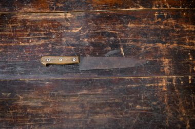 Kırsal ahşap bir kesme tahtasındaki paslı mutfak bıçağı, telif alanı görüntüsüyle merkeze yerleştirilmiş.