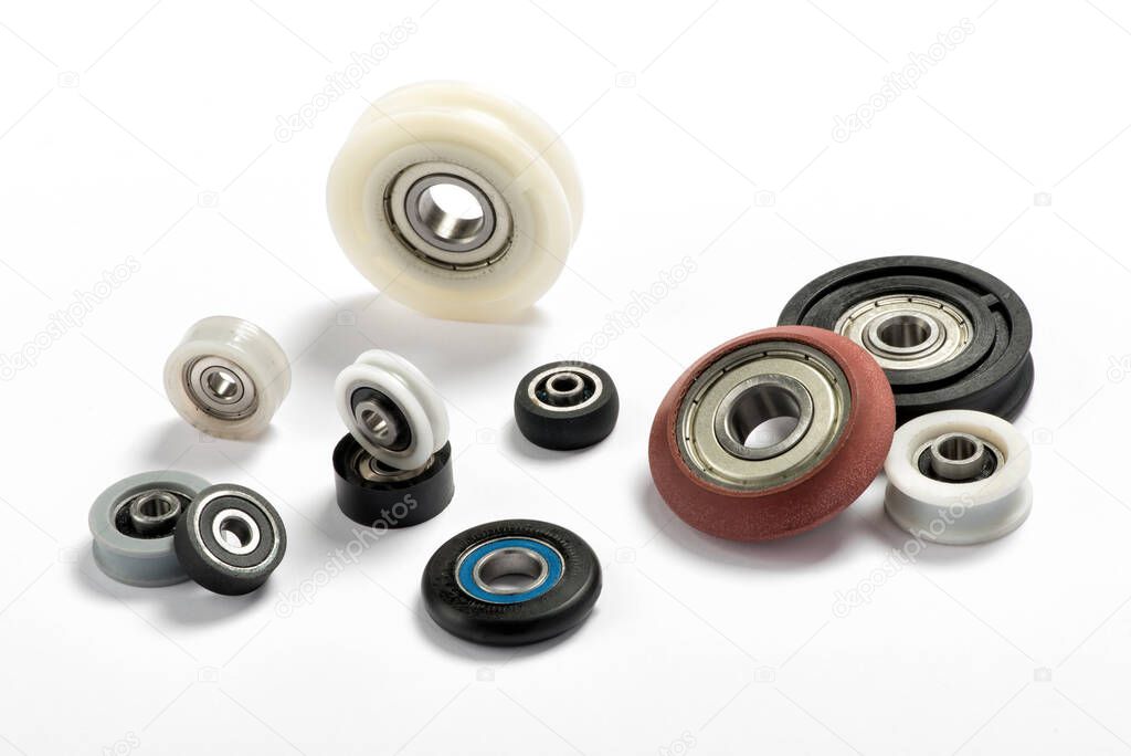 Minimalistic composition with assorted ball bearings of different colors and sizes arranged on white background for industry and engineering concept