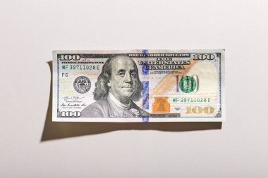 Grunge 100 dolarlık banknotun tepe ve telif boşluklu beyaz bir arka planda gölgesi olan detaylarını anlatıyor.