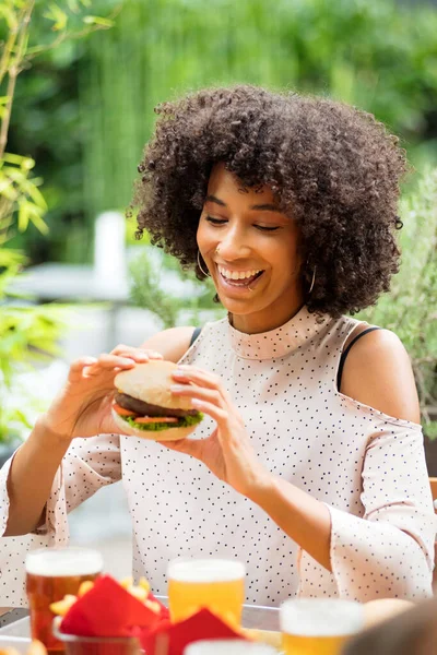 Živý Šťastný Mladý Černošky Žena Jíst Hamburger Drží Rukou Zářivým — Stock fotografie