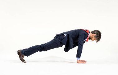 Şık takım elbiseli bir işadamı spor yapıyor. Beyaz üzerine uzun bir kenar açıyla spor yapıyor. Formda ve sağlıklı aktif yaşam tarzı kavramında.