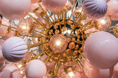 Parlak topları ve parlak yuvarlak şekilli ampulleri olan fütürist avizenin yakın çekimi