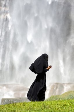 bir akıllı telefon kullanan İslam kadın