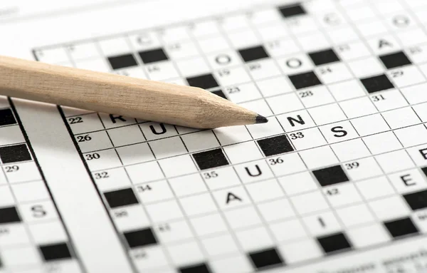 Conceptual Pencil on Top of Crossword Puzzle Paper — Stock Photo, Image