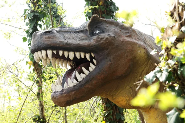 Grande cabeça de um dinossauro alossauro na floresta — Fotografia de Stock