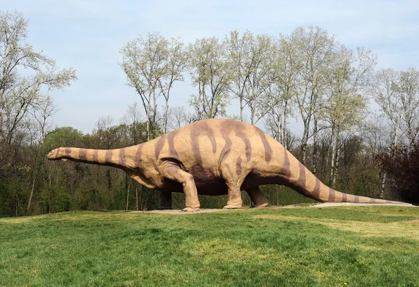 Patung Brontosaurus Besar Berdiri di Taman Grassy Stok Gambar