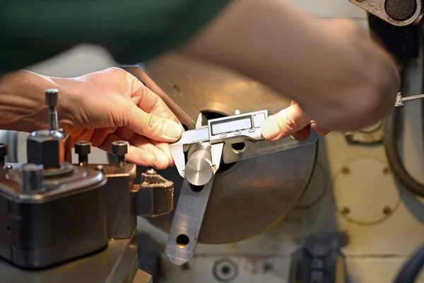 Männlicher Ingenieur beim Messen eines Metallstücks — Stockfoto