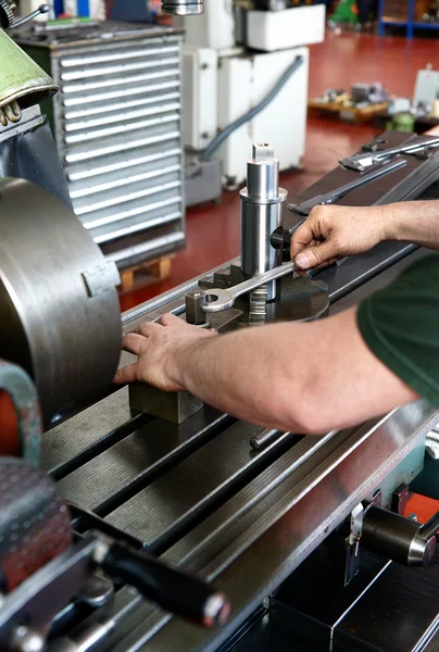 Arbeiter mit einem Schraubenschlüssel, um ein Metallstück zu drehen — Stockfoto