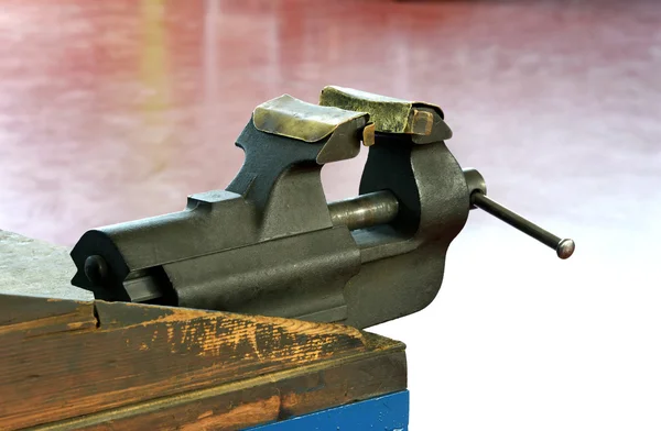 Steel vice mounted on a wooden workbench — Stock Photo, Image
