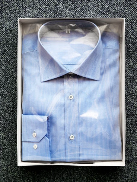 Camisa abatible con botón azul plegado en caja abierta — Foto de Stock