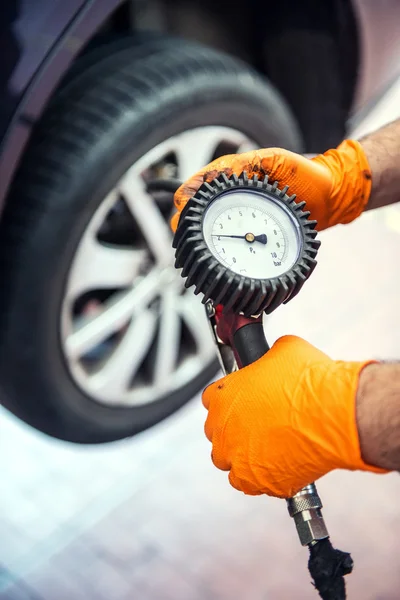 Mechanik samochodowy sprawdzenie ciśnienie w oponach — Zdjęcie stockowe