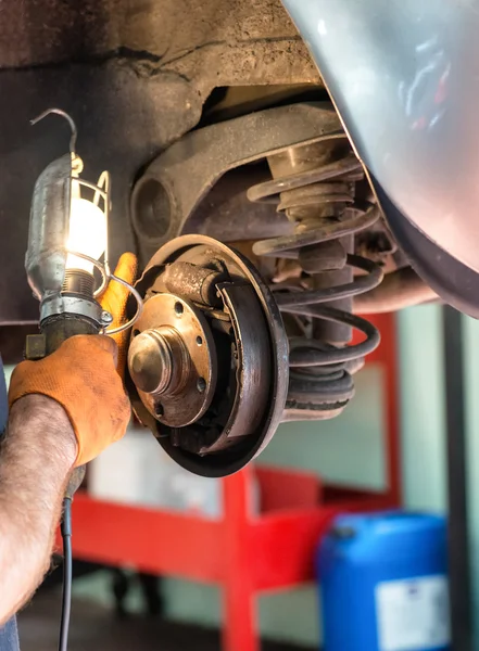 Mechaniker arbeitet an Auto-Bremsen — Stockfoto