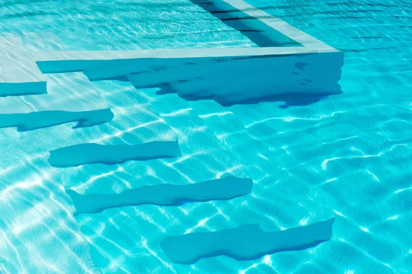 Unterwasserschritte in einem glitzernd blauen Pool — Stockfoto