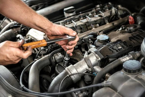 Mechanic met behulp van een sleutel en socket — Stockfoto