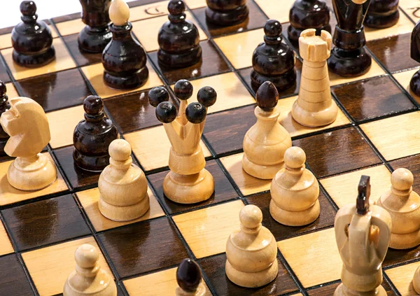 Närbild på schackpjäser på en bräda under en match — Stockfoto