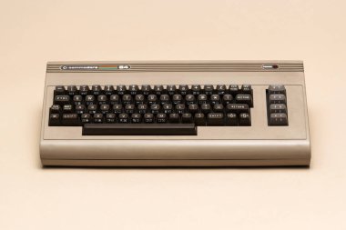 Pavia, Lombardy, İtalya - 8 Aralık 2024: Klasik klavye tasarımlı klasik Commodore 64 ev bilgisayarı, ikonik 8-bit donanım ve retro bilgisayar estetiği. Ctrl + Alt Müzesi 'nde gösterildi.
