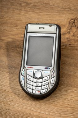 Milan, Lombardy, İtalya - 16 Ocak 2026: Nokia 6630 cep telefonu tahta bir yüzeyde duruyor, 2004 yılından kalma retro iletişim teknolojisini gösteriyor