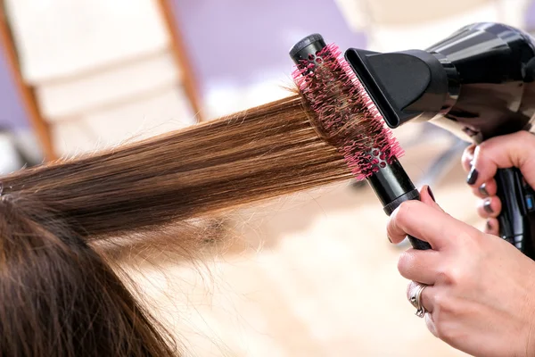 Cabeleireiro golpe secagem longo cabelo castanho — Fotografia de Stock
