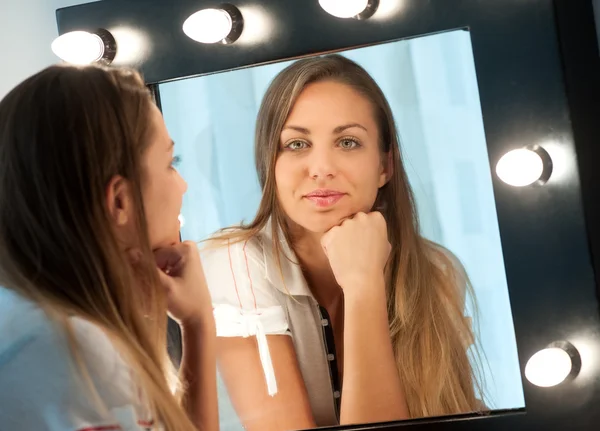 Attractive young girl staring into the mirror — Stock Photo, Image