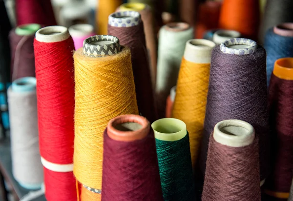 Farbige Baumwollspulen auf Pappkegeln — Stockfoto