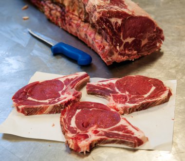 Raw rib eye steak slices on table clipart
