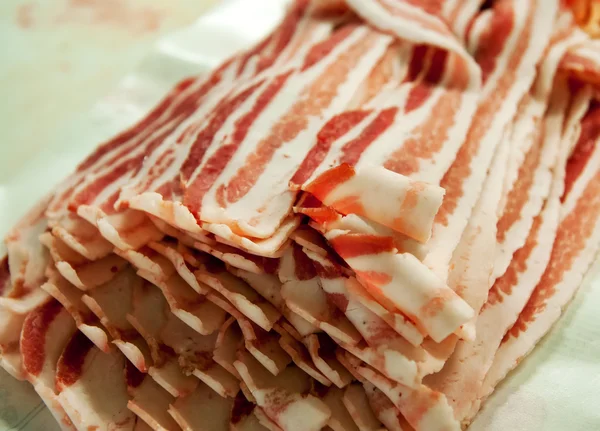 Plátky slaniny v balíčku na stole — Stock fotografie
