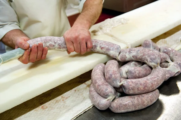 Butcher making links of salami — Stock Photo, Image