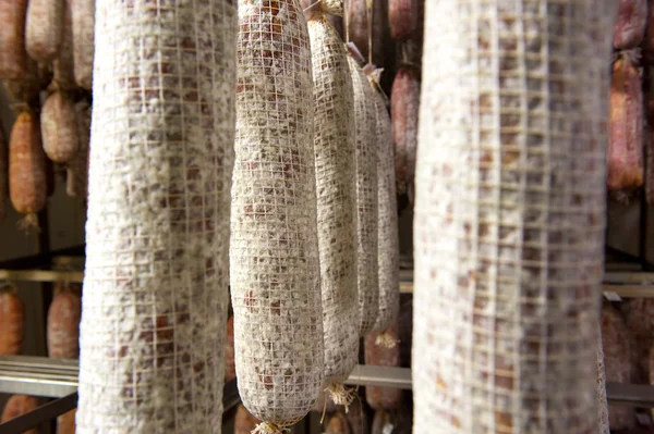 Vergrijzing salami worstjes opknoping in een slagerij — Stockfoto