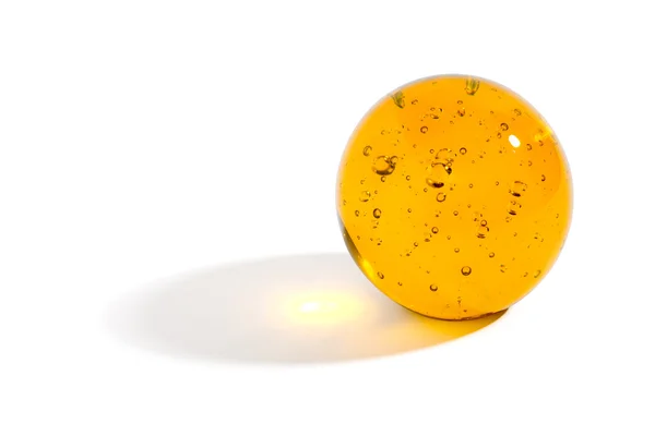 Esfera de vidro amarelo lançando uma sombra — Fotografia de Stock