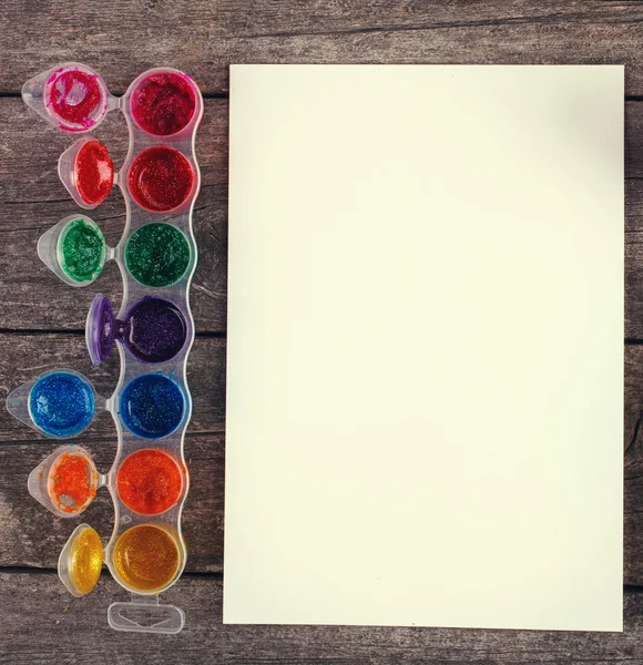 Farby akwarelowe ze szczotkami i arkuszem papieru — Zdjęcie stockowe