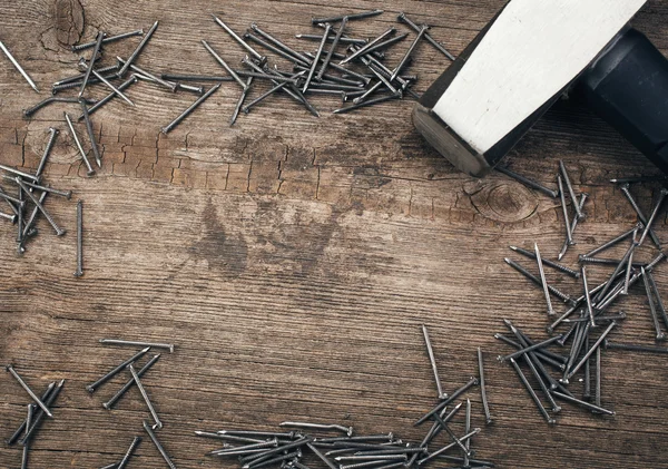 Cromo Martillo y clavos en tablero de madera —  Fotos de Stock