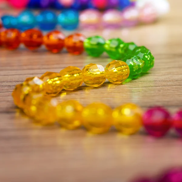 Serpent de perles de couleur sur un fond en bois — Photo