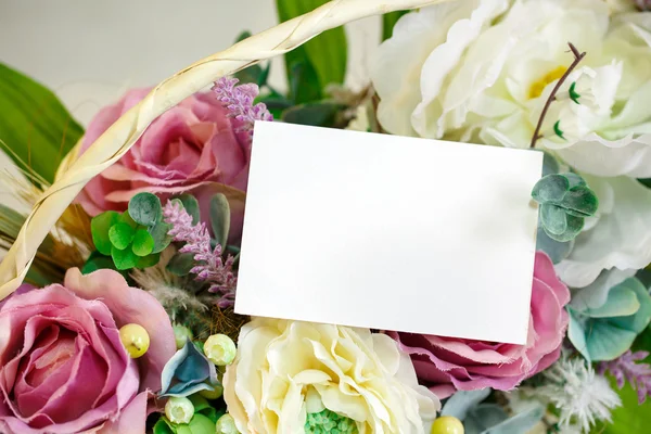 Flowers in basket on the light wooden background. Space for text. — Stock Photo, Image