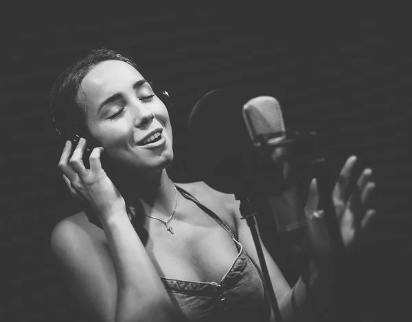 Retro vrouw opname van het geluid in de professionele studio met mic en telefoons. — Stockfoto