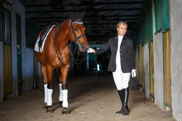 Portret van een meisje ruiter in de buurt van haar bruin paard. Maak je klaar voor het rijden — Stockfoto