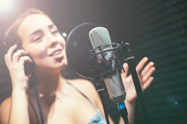 Chica cantando en un micrófono en el estudio —  Fotos de Stock