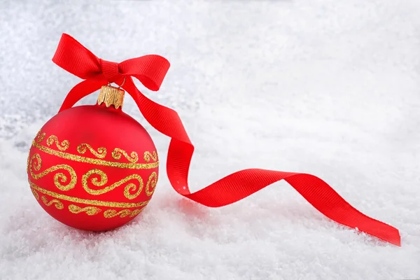 Bola de Natal vermelho com fita na neve — Fotografia de Stock