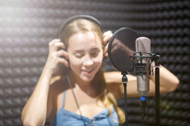 mikrofona bir stüdyoda şarkı söyleyen kız