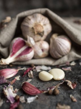 Sarımsak temizleme işlemi. Tahta arka planda sarımsak ve yapraklar. Sarımsağın atmosferik fotoğrafı.