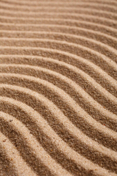 Sand on the beach close up. Wavy texture sand. Selective focus.