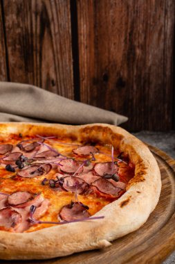 Etli, peynirli ve fesleğenli İtalyan pizzası..