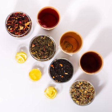 Beyaz arka planda kağıt bardakta bir sürü çay var. Üst görünüm.