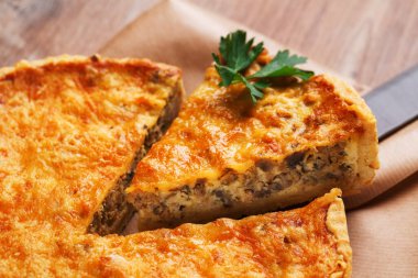 Köy ahşap masada geleneksel sebze turtası. Mantar ve peynirle doldurulmuş dilimlenmiş turta. Kapat..