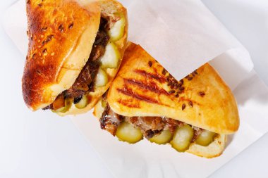 Beyaz arka planda etli ve turşulu güzel kokulu çörekler. Sokak yemekleri konsepti. Üst görünüm, kapat.