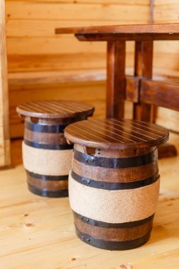 Tahta varil, ahşap bir evin odasındaki masada oturmak için demir çemberler ve sicim iplikçikleriyle süslenir. Tahta mobilyalar. İç dekorasyon. Kapatın. Çevre dostu mobilyalar ve tarz kavramı.