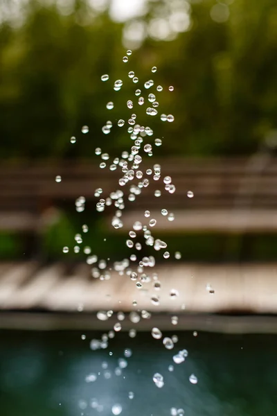 自然の緑の背景にスプラッシュから現れる水の多くの滴の閉じます 背景がぼやけている 選択的フォーカス マクロ写真 — ストック写真