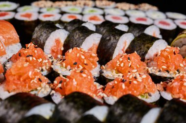 Japon restoran menüsü. Taze somon, salatalık ve susam tohumlarıyla doldurulmuş haşhaş tohumlarını kapatın. Seçici odak.