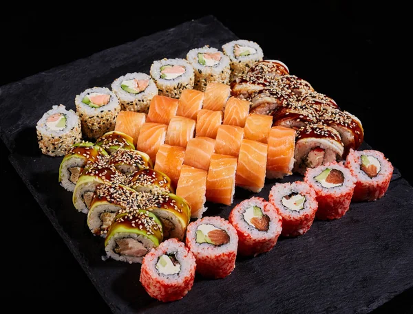 大型方块石板 装有不同类型的寿司卷 日本传统烹饪 Sashimi和Nigiri寿司 — 图库照片