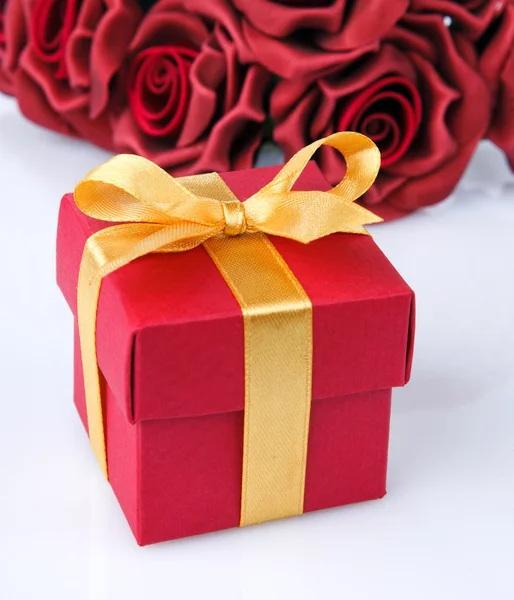 Flores rojas y caja de regalo — Foto de Stock