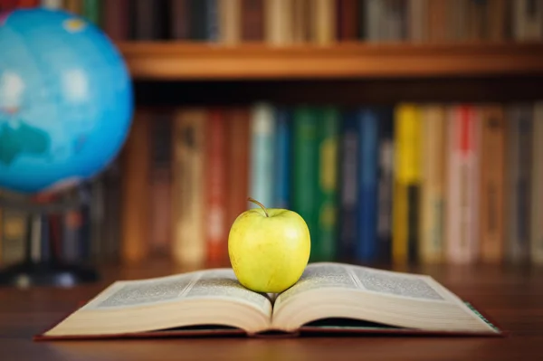 Grönt äpple på öppna boken — Stockfoto